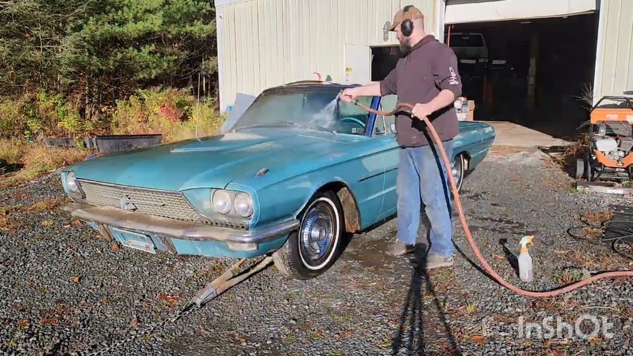 A turquoise 1966 Ford Thunderbird being washed outside the shop